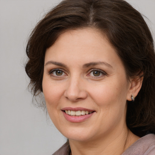 Joyful white adult female with long  brown hair and brown eyes