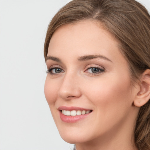 Joyful white young-adult female with long  brown hair and grey eyes