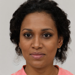 Joyful black adult female with medium  brown hair and brown eyes