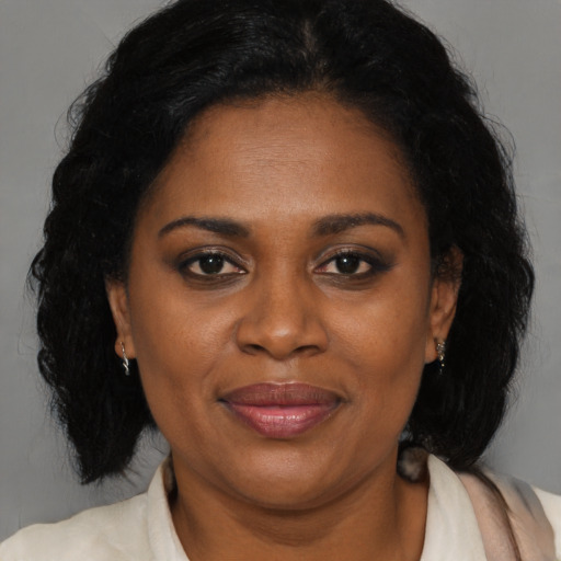Joyful latino adult female with medium  brown hair and brown eyes