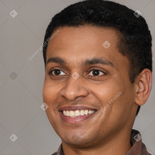 Joyful black young-adult male with short  black hair and brown eyes