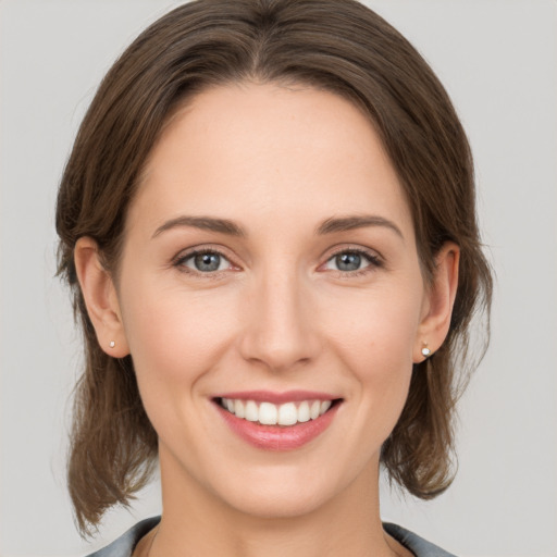 Joyful white young-adult female with medium  brown hair and grey eyes