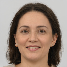 Joyful white adult female with medium  brown hair and grey eyes