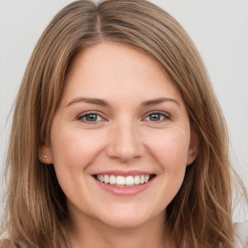 Joyful white young-adult female with long  brown hair and grey eyes