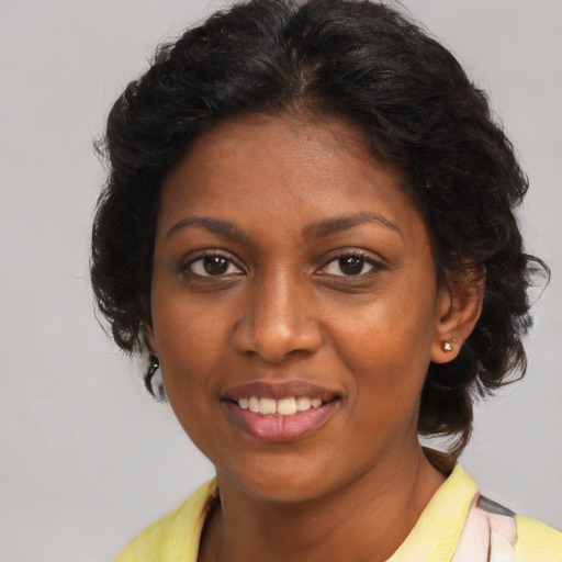 Joyful black young-adult female with medium  brown hair and brown eyes