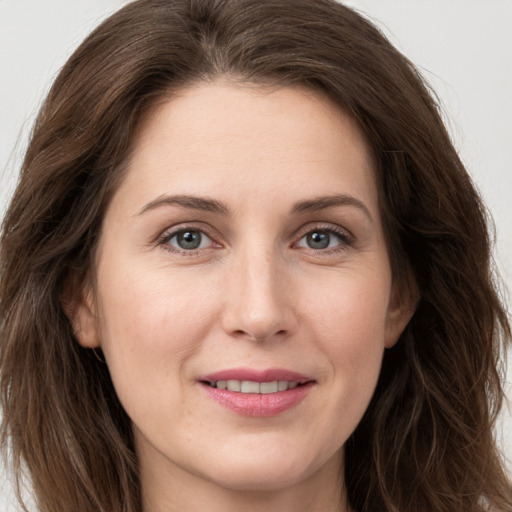 Joyful white young-adult female with long  brown hair and grey eyes