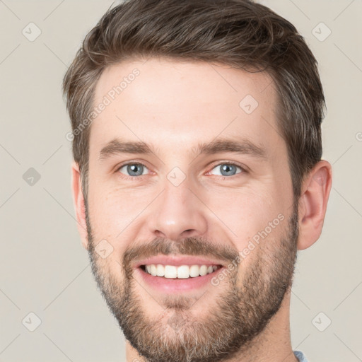 Joyful white young-adult male with short  brown hair and grey eyes