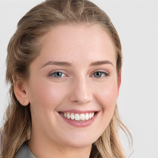 Joyful white young-adult female with long  brown hair and blue eyes