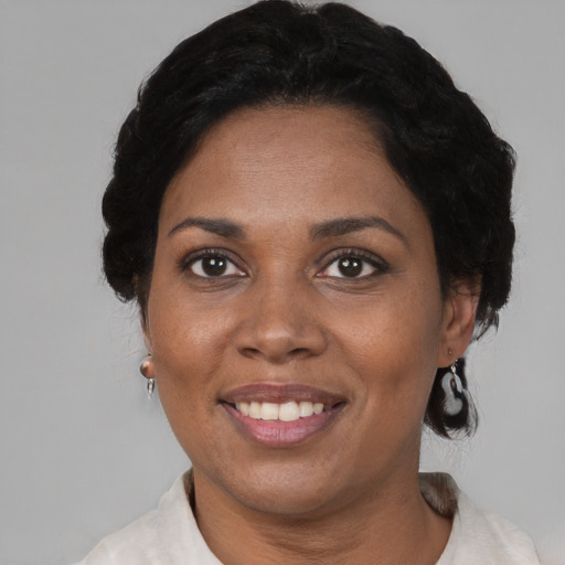 Joyful black adult female with short  brown hair and brown eyes