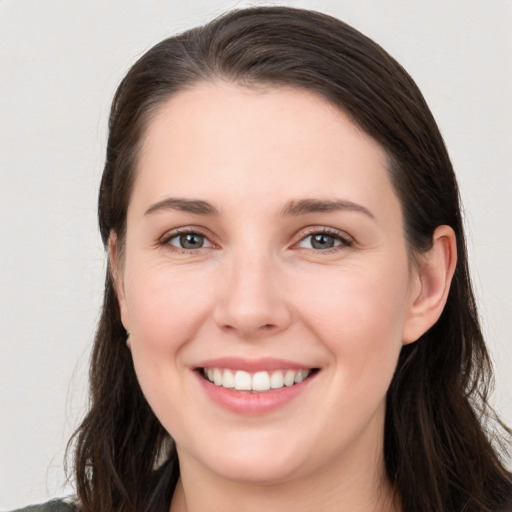 Joyful white young-adult female with long  brown hair and brown eyes