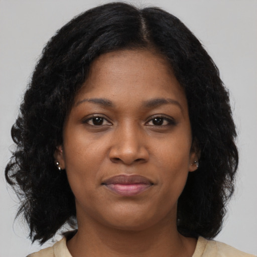 Joyful black young-adult female with long  brown hair and brown eyes