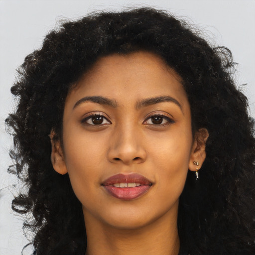Joyful black young-adult female with long  brown hair and brown eyes