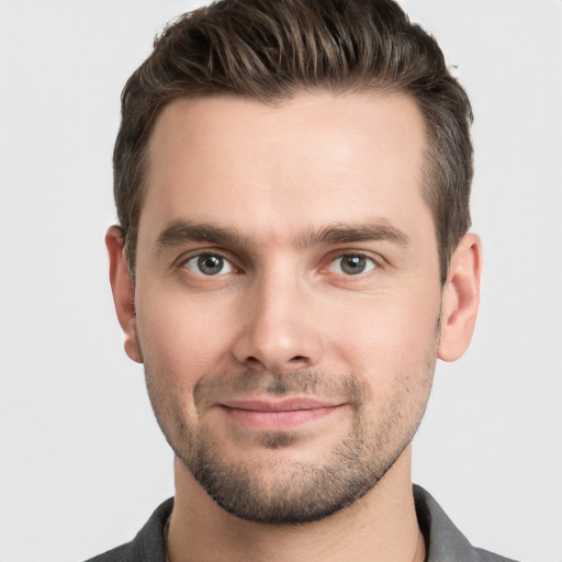 Joyful white young-adult male with short  brown hair and grey eyes