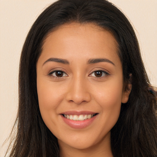 Joyful latino young-adult female with long  brown hair and brown eyes