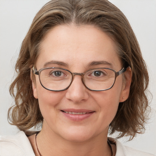 Joyful white adult female with medium  brown hair and blue eyes