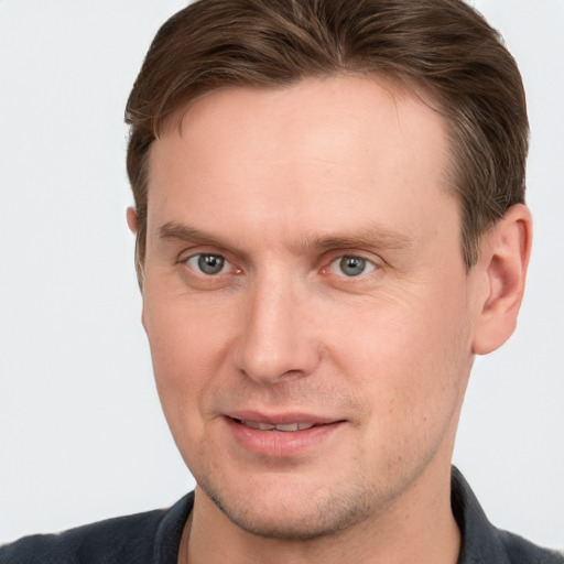 Joyful white adult male with short  brown hair and grey eyes