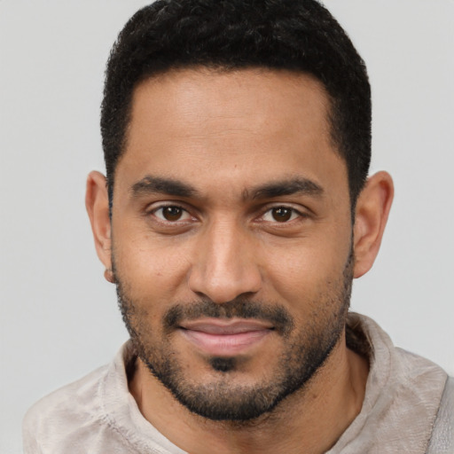 Joyful latino young-adult male with short  black hair and brown eyes