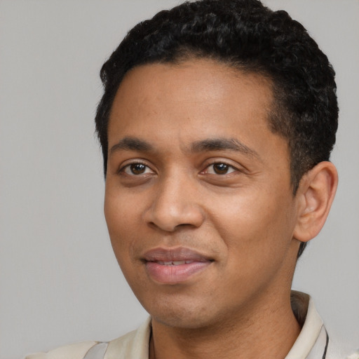 Joyful latino young-adult male with short  black hair and brown eyes