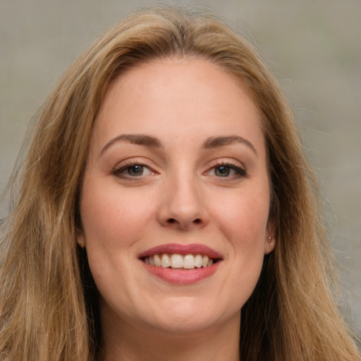 Joyful white young-adult female with long  brown hair and green eyes