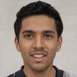 Joyful white young-adult male with short  black hair and brown eyes