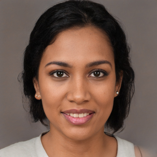 Joyful black young-adult female with medium  brown hair and brown eyes