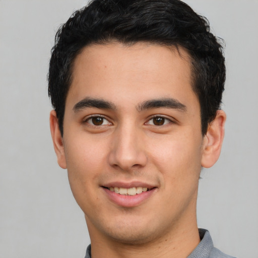 Joyful latino young-adult male with short  black hair and brown eyes