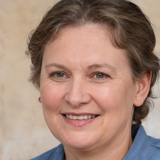 Joyful white adult female with medium  brown hair and blue eyes