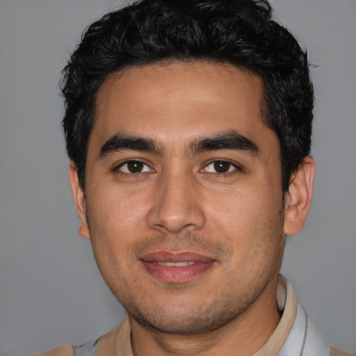 Joyful latino young-adult male with short  black hair and brown eyes
