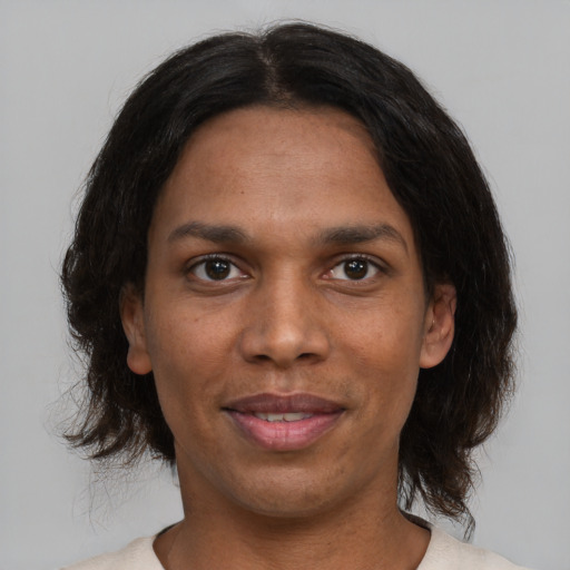 Joyful black adult female with medium  brown hair and brown eyes