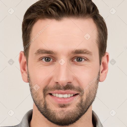 Joyful white young-adult male with short  brown hair and grey eyes