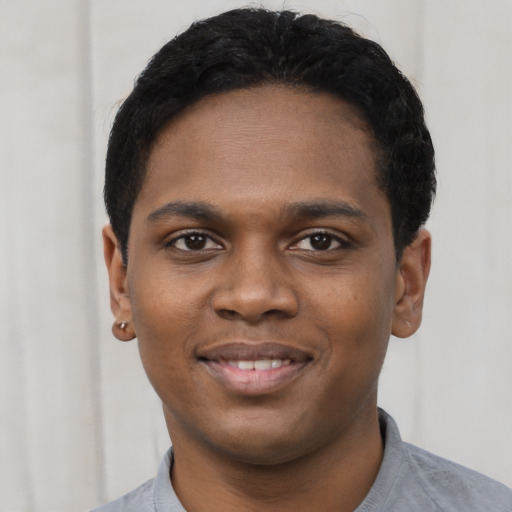 Joyful black young-adult male with short  black hair and brown eyes