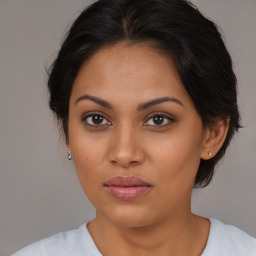 Joyful latino young-adult female with medium  brown hair and brown eyes