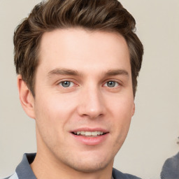 Joyful white young-adult male with short  brown hair and grey eyes