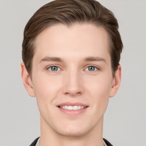 Joyful white young-adult male with short  brown hair and grey eyes