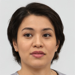 Joyful asian young-adult female with medium  brown hair and brown eyes