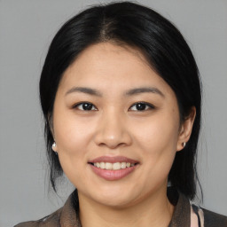 Joyful asian young-adult female with medium  black hair and brown eyes