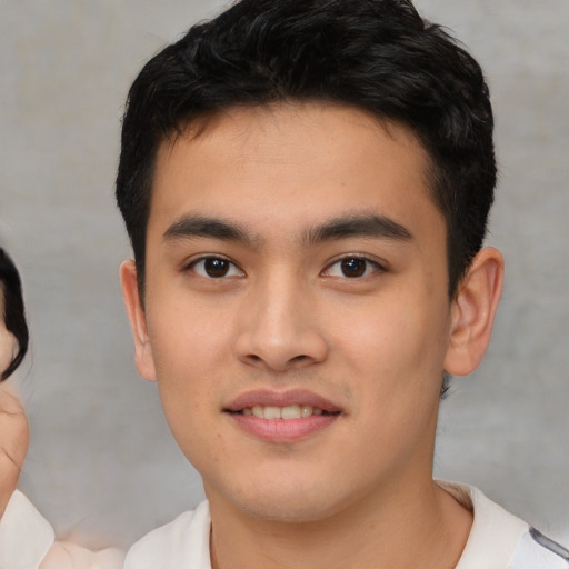 Joyful asian young-adult male with short  black hair and brown eyes