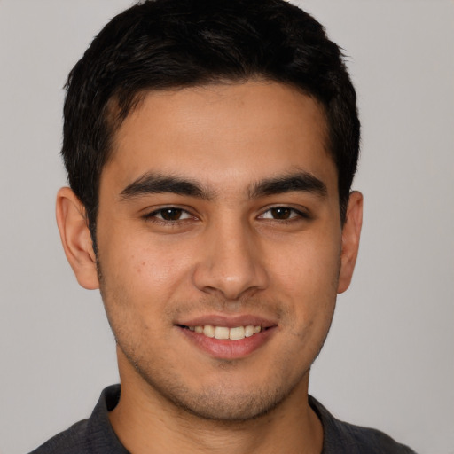 Joyful latino young-adult male with short  brown hair and brown eyes