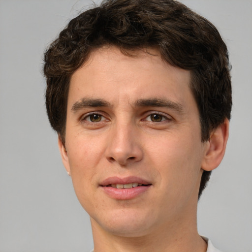 Joyful white young-adult male with short  brown hair and green eyes