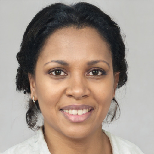 Joyful black adult female with medium  brown hair and brown eyes