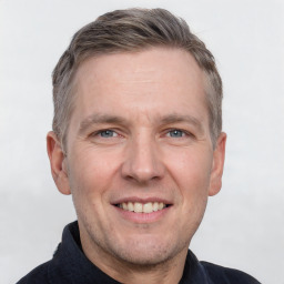 Joyful white adult male with short  brown hair and grey eyes