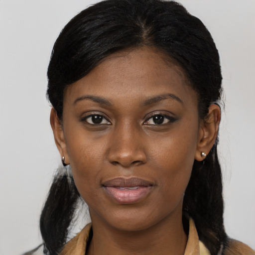 Joyful black young-adult female with long  black hair and brown eyes