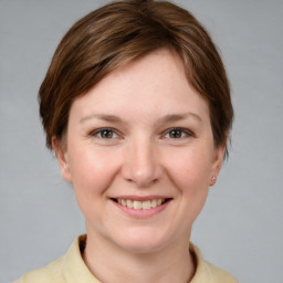 Joyful white young-adult female with short  brown hair and grey eyes