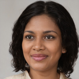 Joyful black young-adult female with medium  brown hair and brown eyes