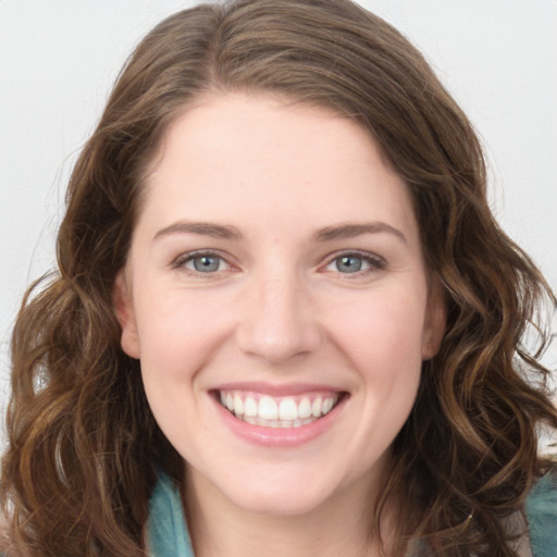 Joyful white young-adult female with long  brown hair and green eyes