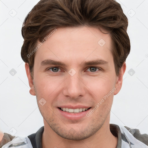 Joyful white young-adult male with short  brown hair and grey eyes