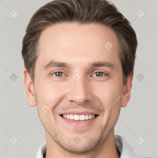 Joyful white young-adult male with short  brown hair and grey eyes