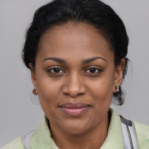 Joyful black adult female with short  black hair and brown eyes