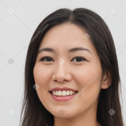 Joyful asian young-adult female with long  brown hair and brown eyes