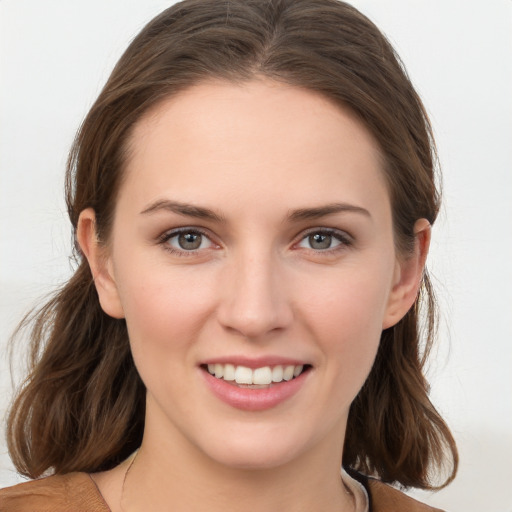 Joyful white young-adult female with medium  brown hair and grey eyes